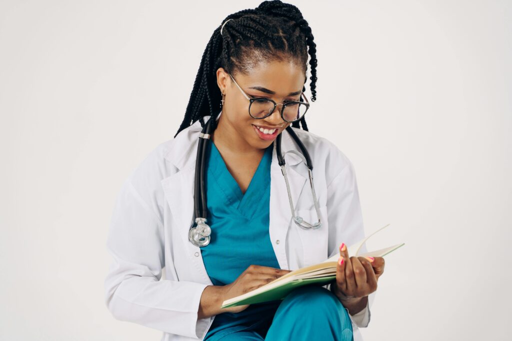 Smiling female doctor with stethoscope reading medical documents.